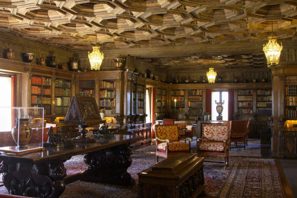 Hearst Library is dark but beautiful with a wood ceiling. Red color furniture accents and lanterns for lighting.