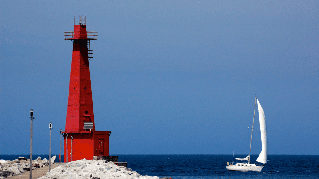 Muskegon is one of the best small towns  in Michigan - look at this lighthouse and sail boat on beautiful blue sparkling water.