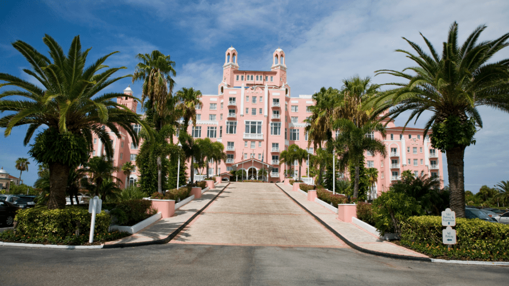 Pink hotel with a grand driveway that elevates the second floor of the hotel. Hotels in St Pete Beach