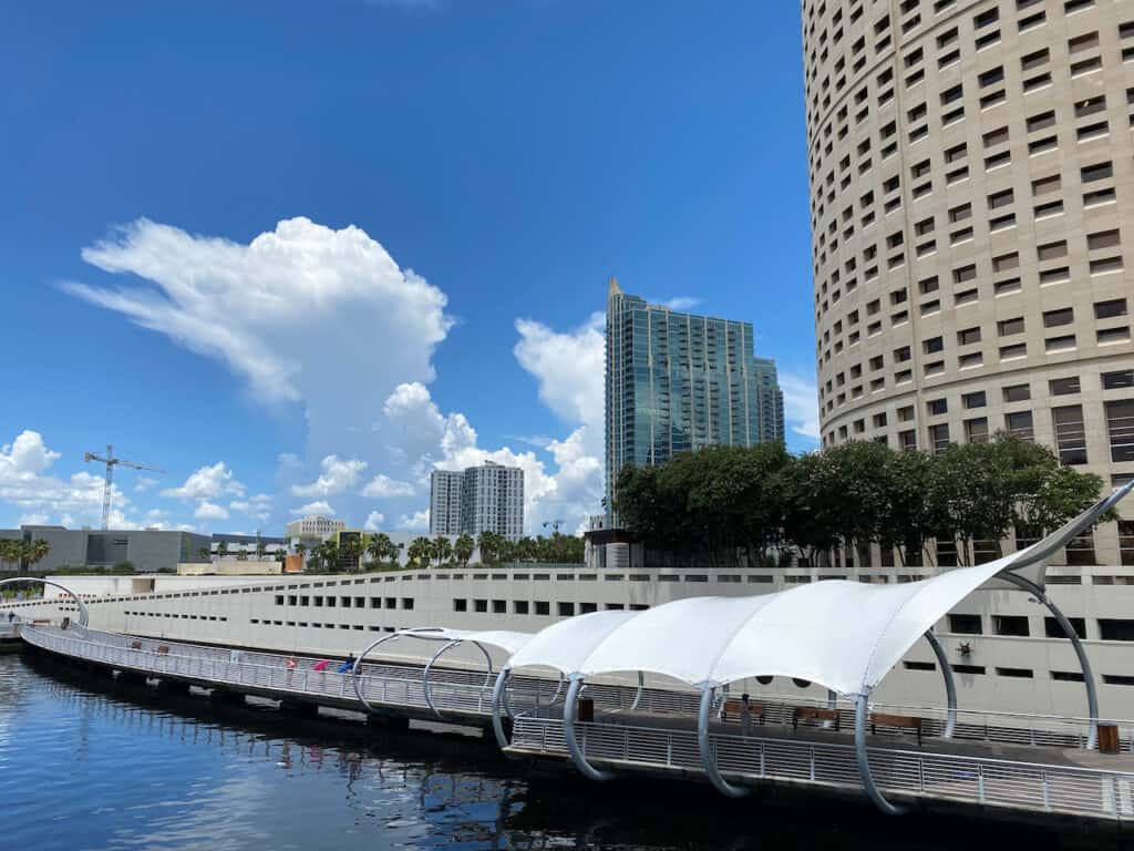 Photo of tall downtown Tampa buildings, Hillsborough River, and the Riverwalk. 