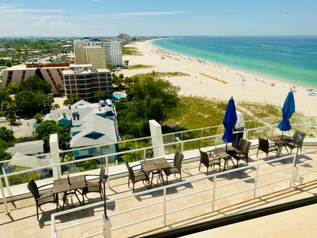 Spectacular views from Level 11 Rooftop Bar & Lounge.  Photo shows outdoor seating and tables with Gulf of Mexi o views.