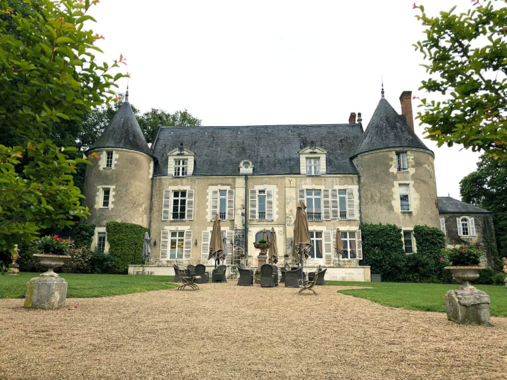 Chateau de Pray in Ambroise, France exterior photo of the beautiful chateau with ornate details around the windows and patio furniture out front.