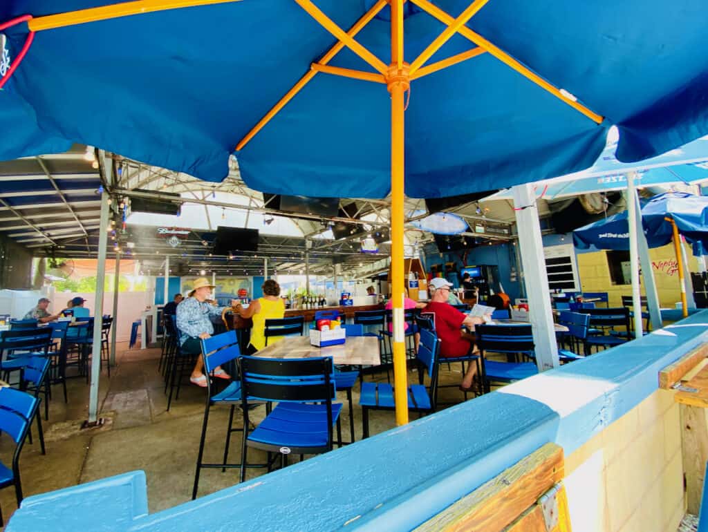 Outdoor dining and bar at Neptune Grill in Gulfport Florida.  This is one of the best bars for volleyball and beach views. 