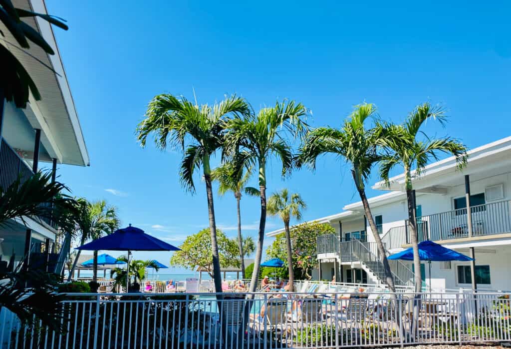St Pete Beach Cheap Hotels, The Bon-Aire Resort has a white and green exterior with motel style set up.