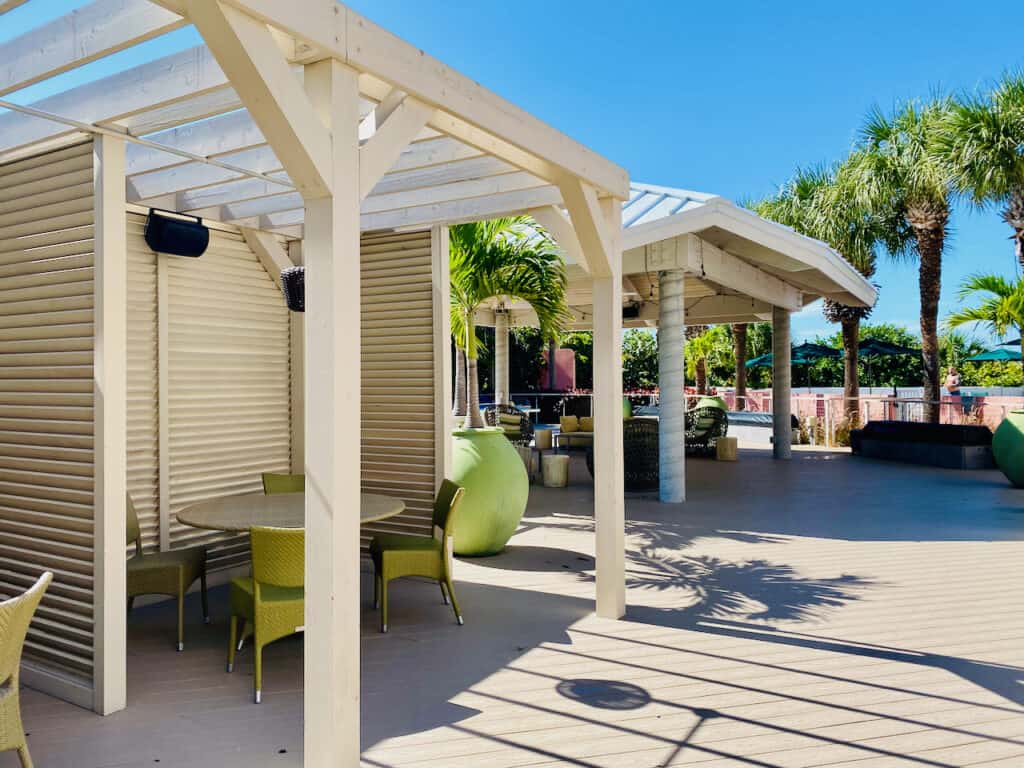 Beach House Suites by Don Cesar shows the outside bar seating and pool area with covered gazebos