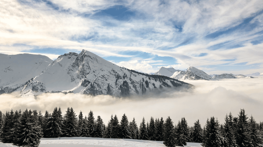 Morzine French Alps photo with evergreens below the mountains.