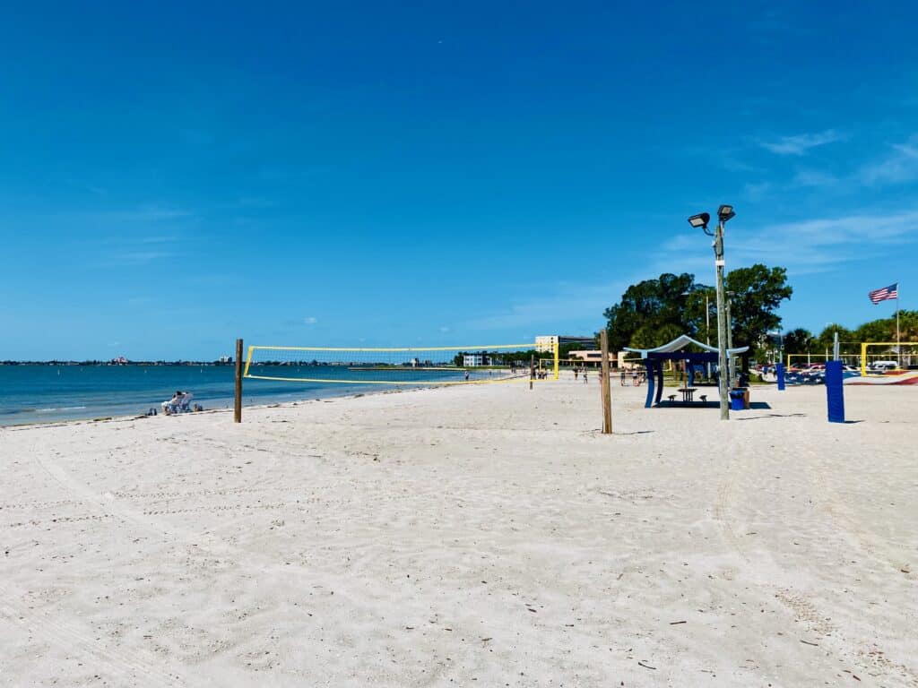 Gulfport Beach in Gulfport, FL shows the volleyball nets, playgrounds and beach area.