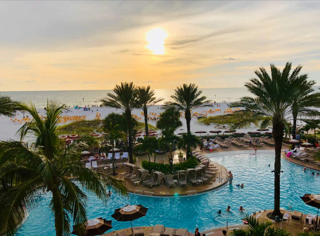 where to stay in clearwater beach, sandpearl resort photo of the beautiful pool and beach sunset in the distance.