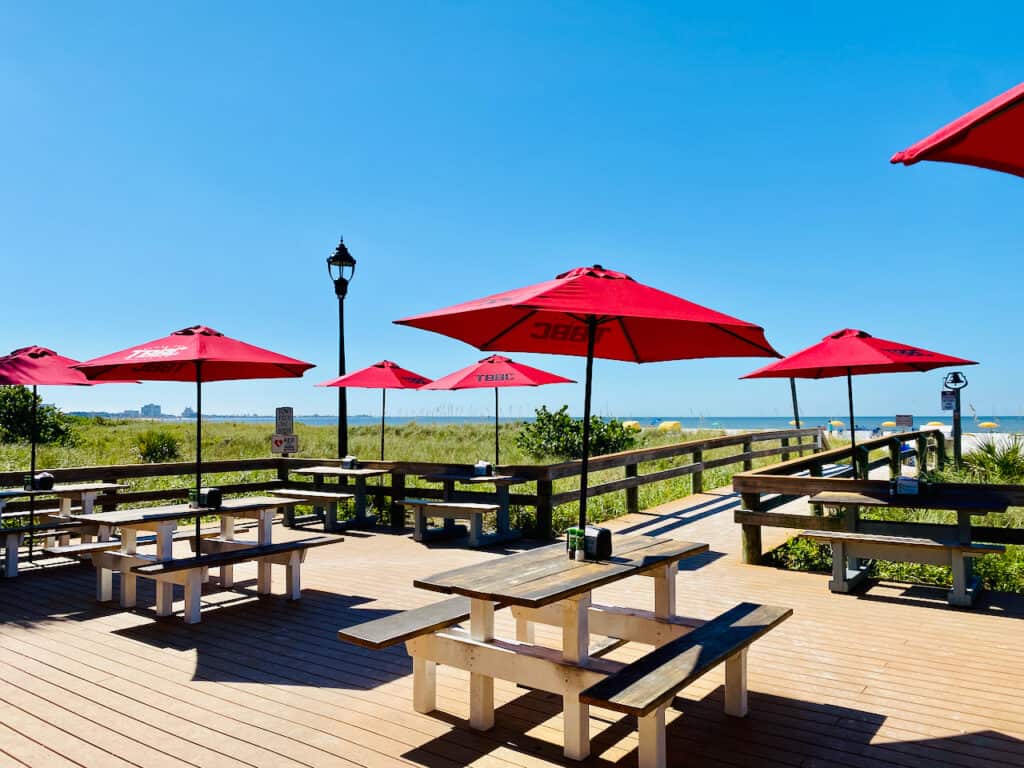 Paradise Grille at Upham Beach Park has lots of shaded seating with red umbrella tops.