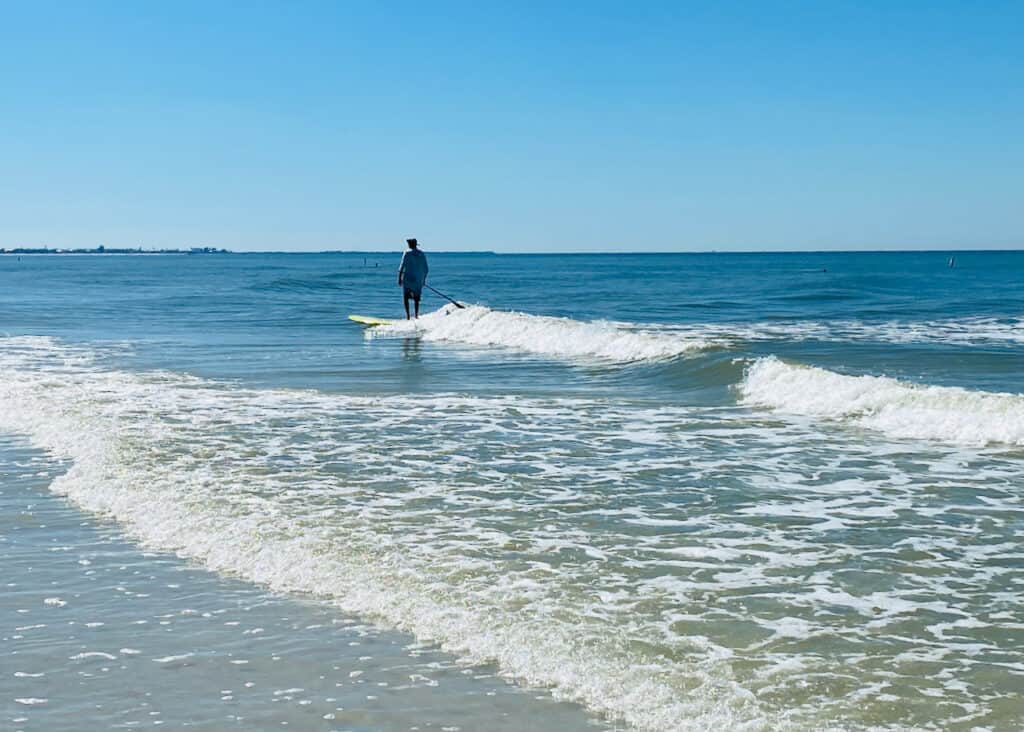 Gulf of mexico view of a man paddleboarding at upham beach fl