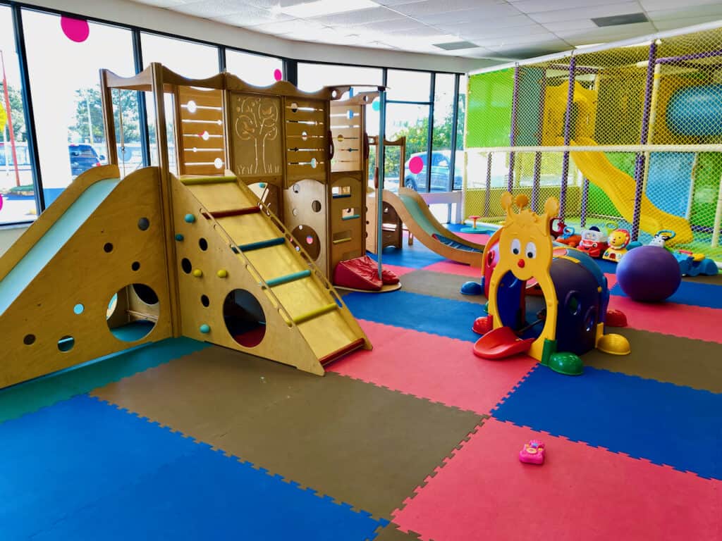 Munchkintown indoor play gym, toys, and riding toys in the background.