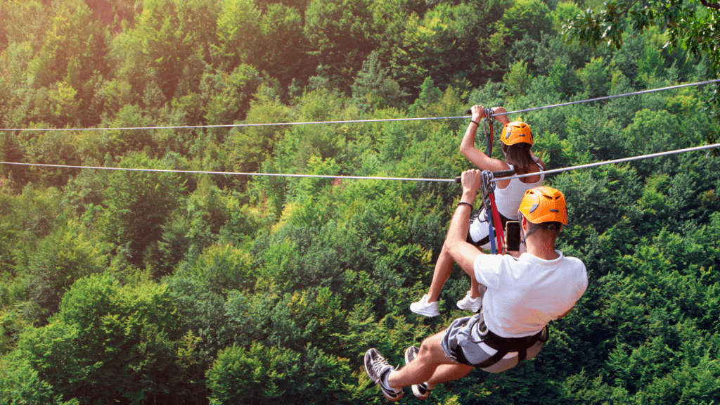 Zipline photo with a couple on two separate lines headed down the line. 