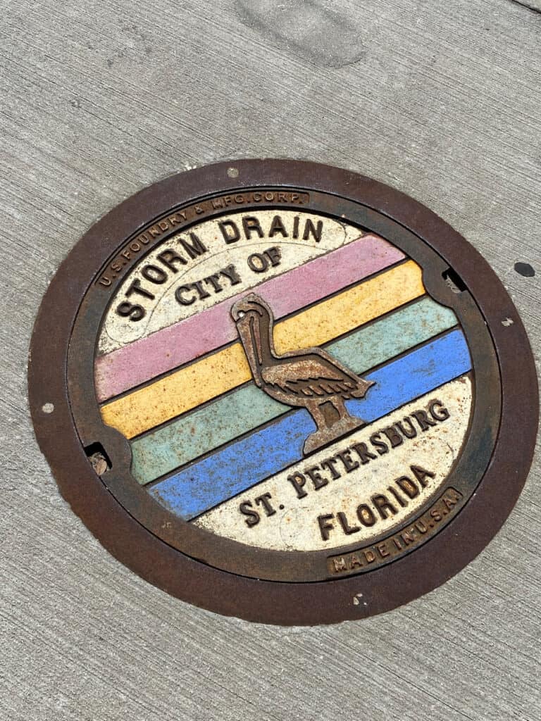 storm drain with color rainbow painted on it.