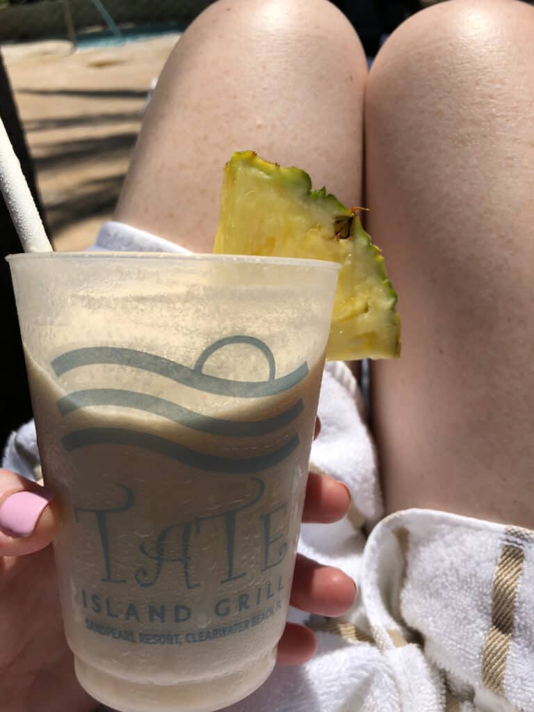 Enjoying the outdoor pool. Erin in a beach towel with Daquiri at Tate Island Grill at The Sand Pearl Resort in Clearwater Beach. Pineapple piece attached to the cup.