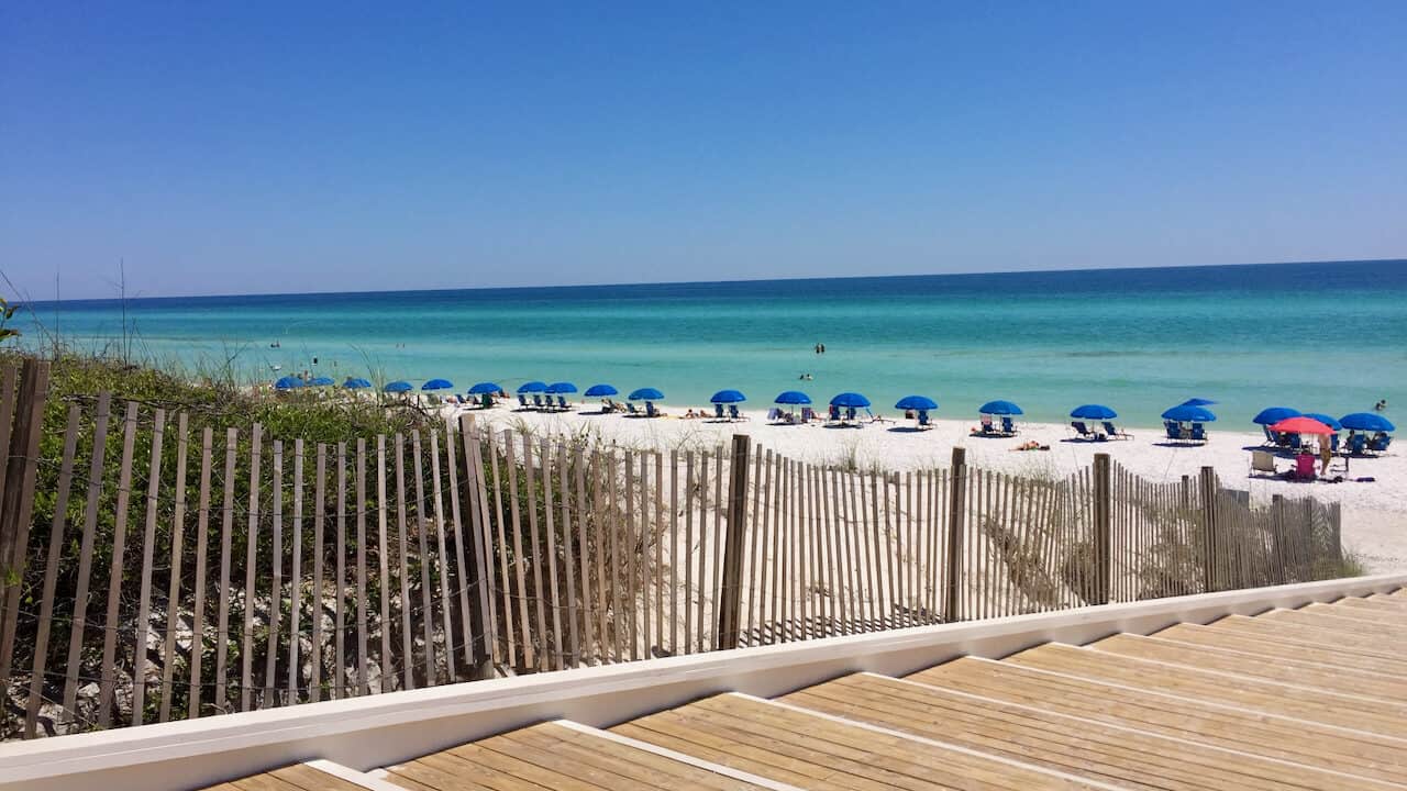 Seaside Beach Access in Seaside Florida. Beautiful blue cabanas in the distance sitting next to the turquoise water.