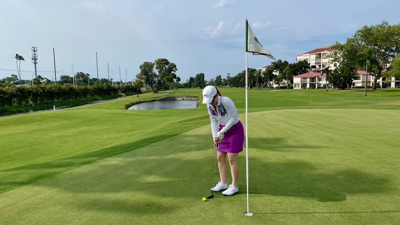 Erin golfing in Florida; putting on green. 