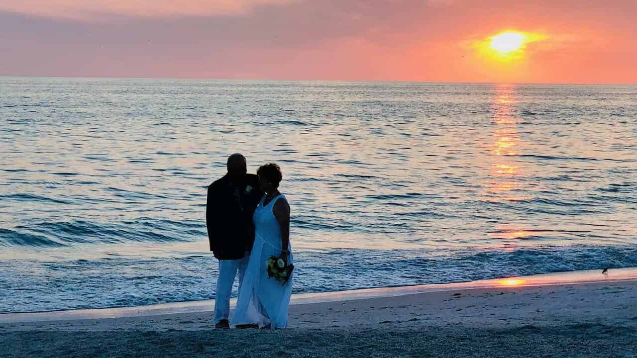 Anna Maria Island couple walking the beach at sunset after their wedding.