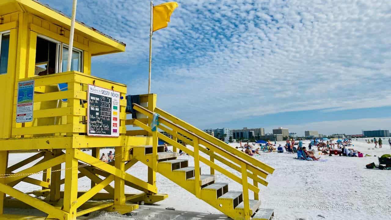 Siesta Key - photo of the yellow life guard station with people sun bathing