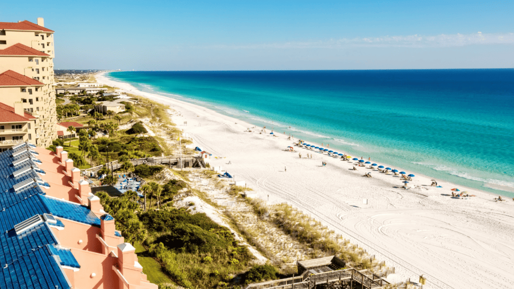 Destin beach photo of emerald green water and people sitting by the water
